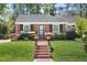 Charming brick home featuring a manicured lawn, brick walkway and lush landscaping at 1109 Huntington Ave, Durham, NC 27707