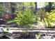 Close-up of garden with metal flower sculptures, plants and mulch at 1109 Huntington Ave, Durham, NC 27707