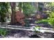 Landscaped garden featuring mulch, flower beds, stepping stones and a whimsical metal flower sculpture at 1109 Huntington Ave, Durham, NC 27707