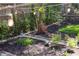 Landscaped garden featuring mulch, flower beds, a whimsical metal sculpture, string lights, and a serene buddha statue at 1109 Huntington Ave, Durham, NC 27707