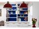 A kitchen featuring a built-in bookshelf, white cabinets and red pendant lights above the island at 1109 Huntington Ave, Durham, NC 27707