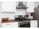 A kitchen showcasing stainless steel appliances, wooden countertops, and bright white subway tile at 1109 Huntington Ave, Durham, NC 27707