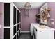 Laundry room with washer and dryer, purple walls, and storage at 1109 Huntington Ave, Durham, NC 27707