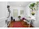 Bright and airy office with a writing desk, colorful rug, and hanging plants at 1109 Huntington Ave, Durham, NC 27707