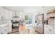 Bright kitchen featuring white cabinets, stainless steel appliances, island, and sliding door to deck at 111 Dunstan Ave, Durham, NC 27707