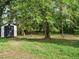 Spacious backyard with mature trees and a storage shed, offering plenty of room for outdoor activities at 1116 Holburn Pl, Raleigh, NC 27610
