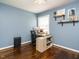Blue bedroom featuring hardwood floors, floating shelves, and a dedicated workspace at 1116 Holburn Pl, Raleigh, NC 27610