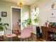 Bright dining area with a glass table, velvet chairs, modern light fixture, and abundant natural light from the window at 1116 Holburn Pl, Raleigh, NC 27610
