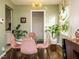 Chic dining room featuring a glass table, plush pink chairs, modern light fixture, and a view into the kitchen at 1116 Holburn Pl, Raleigh, NC 27610