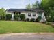 Charming single-story home featuring a well-maintained lawn, lush shrubbery, and a quaint covered front porch at 1116 Holburn Pl, Raleigh, NC 27610