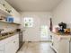Well-lit kitchen with white cabinets, granite countertops, and access to the outdoor patio at 1116 Holburn Pl, Raleigh, NC 27610