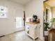 Cozy kitchen with white cabinets, tiled floors, and convenient access to the back door and hall at 1116 Holburn Pl, Raleigh, NC 27610