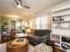 Stylish living room with a comfortable gray couch, round wood table, ceiling fan, and built-in shelving at 1116 Holburn Pl, Raleigh, NC 27610