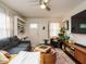 Inviting living room with a gray sofa, ceiling fan, modern entertainment center, and a bright front door at 1116 Holburn Pl, Raleigh, NC 27610