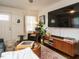 Bright living room with a large television, modern wood cabinet, comfortable armchair, and stylish home decor at 1116 Holburn Pl, Raleigh, NC 27610