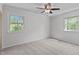 Cozy bedroom with carpet, two windows, and a ceiling fan at 1120 Shetland Ct, Raleigh, NC 27609