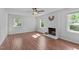 Bright living room featuring wood floors, a ceiling fan, and a brick fireplace at 1120 Shetland Ct, Raleigh, NC 27609