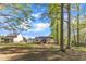 Large backyard with a cozy gazebo, fire pit, and well-maintained lawn surrounded by mature trees at 119 Wolf Creek Dr, Wendell, NC 27591