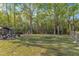 Picture of a spacious backyard with a gazebo and a fire pit with Adirondack chairs surrounded by mature trees at 119 Wolf Creek Dr, Wendell, NC 27591