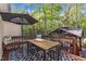 Backyard deck with table, chairs, bench, and an umbrella provides a cozy outdoor dining area with a view of the gazebo at 119 Wolf Creek Dr, Wendell, NC 27591