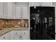 Close-up of the kitchen features black refrigerator, granite counters, and decor at 119 Wolf Creek Dr, Wendell, NC 27591