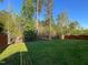 Spacious backyard featuring lush green grass, a fence, and surrounding wooded area at 120 Putters Ct, Durham, NC 27703