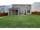 View of the home's backyard featuring a screened-in porch and a well-manicured lawn at 120 Putters Ct, Durham, NC 27703