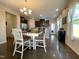 Dining area adjacent to the kitchen featuring modern lighting and ample natural light from surrounding windows at 120 Putters Ct, Durham, NC 27703