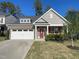 Charming home features a brick facade, two-car garage, manicured lawn, and a welcoming red front door at 120 Putters Ct, Durham, NC 27703