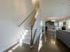 Hallway featuring hardwood floors, stairway, and an open view into the dining and kitchen areas at 120 Putters Ct, Durham, NC 27703