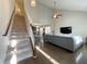Open-concept living room with high ceilings, hardwood floors, and staircase access to the upper floor at 120 Putters Ct, Durham, NC 27703