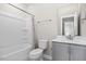 Bathroom with white tub, modern vanity with gray cabinets, and a combined shower at 1203 Great Egret Way, Durham, NC 27713