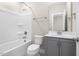 Bathroom with white tub, modern vanity with gray cabinets, and a combined shower at 1203 Great Egret Way, Durham, NC 27713