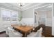 Inviting dining room with wood table and white chairs under decorative chandelier with large sunlit windows at 1203 Great Egret Way, Durham, NC 27713