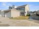 View of the townhouse's exterior with gray siding, a driveway, and a two-car garage at 1203 Great Egret Way, Durham, NC 27713