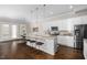 Kitchen boasts white cabinets, stainless appliances, a marble countertop island with bar stools and pendant lighting at 1203 Great Egret Way, Durham, NC 27713
