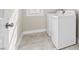 Bright laundry room features tile floors, a window, and a stacked washer and dryer at 1203 Great Egret Way, Durham, NC 27713