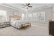 Spacious main bedroom featuring a tray ceiling, ceiling fan, and several windows for natural light at 1203 Great Egret Way, Durham, NC 27713