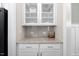 Butler's pantry features granite countertops, white cabinets with glass doors and storage for refreshments at 1203 Great Egret Way, Durham, NC 27713