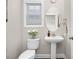 Elegant half bathroom with pedestal sink, oval mirror, and neutral tones, providing a convenient space at 1203 Great Egret Way, Durham, NC 27713