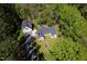 Aerial view of a yellow home, garage, and lush green surroundings at 1208 Goodwin Rd, Apex, NC 27523