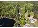 Beautiful aerial view showcases the property's pond and surrounding lush green forest at 1208 Goodwin Rd, Apex, NC 27523