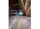 Spacious unfinished attic with insulation and storage shelves, ready for a new owner's creative touch at 1208 Goodwin Rd, Apex, NC 27523