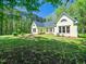 Back exterior of a charming house with mature trees and manicured lawn at 1208 Goodwin Rd, Apex, NC 27523