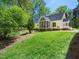 The back exterior of the house with a screened-in porch and a well-kept lawn at 1208 Goodwin Rd, Apex, NC 27523