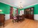 Formal dining room with elegant chandelier, classic furniture, and hardwood floors at 1208 Goodwin Rd, Apex, NC 27523