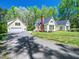 Charming yellow home featuring a brick chimney, a garage, and a well-maintained lawn and gravel driveway at 1208 Goodwin Rd, Apex, NC 27523