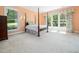 A four-poster bed sits in a sunny main bedroom with large windows and floral curtains at 1208 Goodwin Rd, Apex, NC 27523