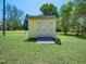Yellow storage shed with double doors on a grassy lot at 1208 Goodwin Rd, Apex, NC 27523