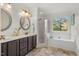 Bright bathroom featuring double sinks, a tub, a shower, and a large window with a scenic view at 1216 Caribou Xing, Durham, NC 27713